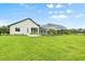 Expansive backyard with lush green lawn, screened-in porch and partial lake view at 7832 Panther Ridge Trl, Bradenton, FL 34202
