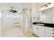 Bright bathroom with a double sink vanity, large mirror, and tub with glass door at 7832 Panther Ridge Trl, Bradenton, FL 34202