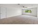 Spacious bedroom with neutral carpet, ceiling fan, and a window overlooking greenery at 7832 Panther Ridge Trl, Bradenton, FL 34202