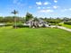 Scenic shot of the home exterior, featuring a spacious lawn, pond view, and elegant landscaping at 7832 Panther Ridge Trl, Bradenton, FL 34202