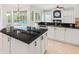 Gourmet kitchen with an island, white cabinets, stainless steel appliances, and a pool view at 7832 Panther Ridge Trl, Bradenton, FL 34202