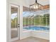 Inviting screened-in pool with lush landscaping viewed from a windowed dining nook at 7832 Panther Ridge Trl, Bradenton, FL 34202