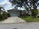 Charming single-story home with lush landscaping and a large shade tree in the front yard at 817 Tallgrass Ln, Bradenton, FL 34212