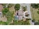 Aerial view of a house with a screened-in pool, a circular driveway, and mature landscaping at 8255 Longbay Blvd, Sarasota, FL 34243