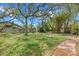 Expansive backyard with lush greenery, a privacy fence, and mature trees at 8255 Longbay Blvd, Sarasota, FL 34243