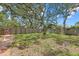 Fenced in backyard with mature trees and a pathway leading through the yard at 8255 Longbay Blvd, Sarasota, FL 34243