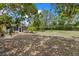 Large, lush backyard with surrounding foliage, trees, and an outdoor seating area at 8255 Longbay Blvd, Sarasota, FL 34243