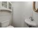 Small, corner bathroom with sink, toilet and built in shelving at 8255 Longbay Blvd, Sarasota, FL 34243
