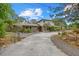 Exterior of home with stone accents, landscaping, and a curved driveway at 8255 Longbay Blvd, Sarasota, FL 34243