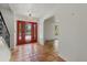 Inviting foyer featuring a red front door, terra cotta floors, and arched doorway at 8255 Longbay Blvd, Sarasota, FL 34243