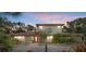 Charming home featuring a stone facade, red door, and lush, tropical landscaping at 8255 Longbay Blvd, Sarasota, FL 34243