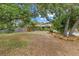 Lush front yard featuring mature trees, landscaping, and a stone façade on the house at 8255 Longbay Blvd, Sarasota, FL 34243