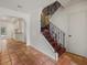 Hallway featuring terra cotta floors, staircase with iron railing, and access to other rooms at 8255 Longbay Blvd, Sarasota, FL 34243