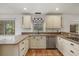 Bright kitchen with white cabinets, granite counters, stainless appliances, and a nature view at 8255 Longbay Blvd, Sarasota, FL 34243