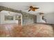 Open living room with terra cotta floors, stone wall, and arched doorways at 8255 Longbay Blvd, Sarasota, FL 34243