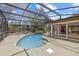 Inviting backyard pool with screened enclosure, waterfall, and lush landscaping at 8255 Longbay Blvd, Sarasota, FL 34243