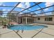 Inviting backyard pool with screened enclosure, waterfall, and lush landscaping at 8255 Longbay Blvd, Sarasota, FL 34243