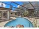 Screened in pool with a unique shape and rock decorations and an attached patio area at 8255 Longbay Blvd, Sarasota, FL 34243