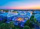 Stunning aerial view of a home with a screened pool enclosure and beautifully landscaped yard at dusk at 8272 Redonda Loop, Bradenton, FL 34202