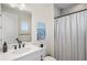 Well-lit bathroom featuring a single vanity, large mirror, and a shower with a striped curtain at 8272 Redonda Loop, Bradenton, FL 34202