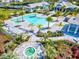 Aerial view of the community pool area with a jacuzzi, sun loungers and lush tropical landscaping at 8272 Redonda Loop, Bradenton, FL 34202