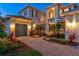 Well-maintained home featuring a paver driveway, beautiful landscaping, and ample lighting at 8272 Redonda Loop, Bradenton, FL 34202