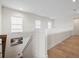 Bright upstairs hallway with hardwood floors and staircase with bright white walls and trim at 8272 Redonda Loop, Bradenton, FL 34202