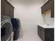 Well-equipped laundry room with dark cabinetry, a sink, and modern washer/dryer at 8272 Redonda Loop, Bradenton, FL 34202