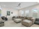 Bright and airy living room featuring a sectional sofa, ceiling fan, and neutral color scheme at 8272 Redonda Loop, Bradenton, FL 34202