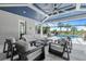 Covered outdoor patio with a pool, dining furniture, and view to palm trees at 8272 Redonda Loop, Bradenton, FL 34202