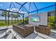 Outdoor pool with a wall-mounted TV and wicker seating area under a screened enclosure at 8272 Redonda Loop, Bradenton, FL 34202