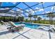 Relax in this stunning caged pool, with in-pool loungers, lush landscaping, and plenty of room for entertaining at 8272 Redonda Loop, Bradenton, FL 34202