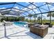 A covered outdoor pool features elegant white tiling and a lounge area perfect for entertaining guests at 8272 Redonda Loop, Bradenton, FL 34202
