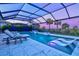Stunning screened pool with modern lounge chairs, a spa, and beautiful tropical landscaping at 8272 Redonda Loop, Bradenton, FL 34202