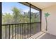This balcony has a scenic view of many trees and black railings at 860 Virginia St # 304, Dunedin, FL 34698