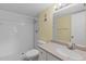 This bathroom features white tiled walls, a white sink and toilet, and a shower with a new showerhead at 860 Virginia St # 304, Dunedin, FL 34698