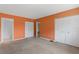 This bedroom features neutral carpet, an orange painted walls, and double door closets at 860 Virginia St # 304, Dunedin, FL 34698