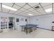 Spacious game room with a ping pong table, folding tables, and storage, ideal for community entertainment at 860 Virginia St # 304, Dunedin, FL 34698