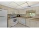 The bright kitchen features white cabinets and appliances, complemented by tile flooring at 860 Virginia St # 304, Dunedin, FL 34698