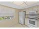Bright kitchen with white appliances and cabinets, plus a window providing ample light at 860 Virginia St # 304, Dunedin, FL 34698