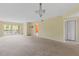 Bright, spacious living room with neutral walls and carpet with a sliding door to a balcony at 860 Virginia St # 304, Dunedin, FL 34698