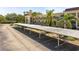 This parking area is covered with tropical trees surrounding the building at 860 Virginia St # 304, Dunedin, FL 34698