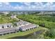 Community aerial view showcasing townhomes, green spaces, and a scenic pond against a cityscape backdrop at 8628 Milestone Dr, Sarasota, FL 34238