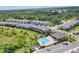 A beautiful aerial view showcases a community pool, townhomes, and a lush green surrounding area at 8628 Milestone Dr, Sarasota, FL 34238