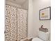 Cozy bathroom featuring a shower with a modern geometric-patterned curtain and toilet with decorative basket at 8628 Milestone Dr, Sarasota, FL 34238