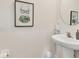 Powder room featuring pedestal sink, decorative mirror, and vibrant tropical themed art at 8628 Milestone Dr, Sarasota, FL 34238