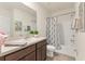 Bathroom featuring a vanity, mirror, toilet, and tub with shower and a blue patterned shower curtain at 8628 Milestone Dr, Sarasota, FL 34238