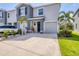Two-story townhome features a gray facade, attached garage and well-maintained landscaping at 8628 Milestone Dr, Sarasota, FL 34238