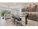 Modern kitchen with granite countertops, stainless steel appliances, and an island with seating overlooking the living area at 8628 Milestone Dr, Sarasota, FL 34238