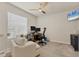 Bright office space with comfortable chair, monitors, ceiling fan, and a cozy white armchair at 8628 Milestone Dr, Sarasota, FL 34238